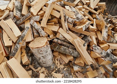 Birch Firewood Is Split Into Pieces And Piled Up. Background From Materials