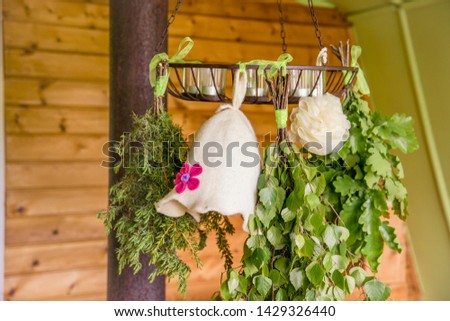 Birch, juniper,oak tree sauna whisks brooms ( also known as vasta, vihta or venik) hanging and drying. Felt woman sauna hat at sponge. Sauna hat keeps hair from damaging and head from overheating.