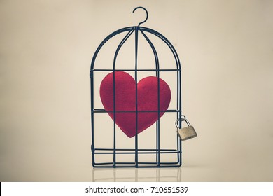 A Bird Cage With A Red Heart Inside