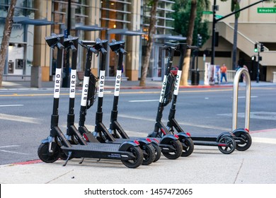 Bird Electric Rideshare Scooters On Sidewalk In City Downtown On Sunny Day. Bird Is A Reliable Last Mile Dockless Electric Scooter Rental Service - San Jose, California, USA - July 21, 2019