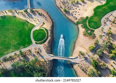 Bird eye view of the golf course with small boat crossing lagoons at tourists town El Gouna in The Red Sea, Egypt 