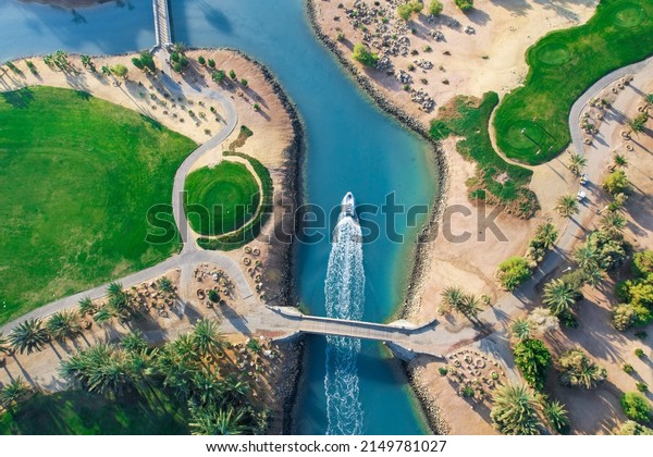 Bird eye\
view of the golf course with small boat crossing lagoons at\
tourists town El Gouna in The Red Sea, Egypt\
