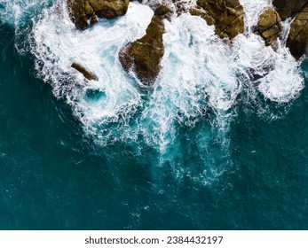 Bird eye view seashore with big wave crashing on rock cliff. Beautiful waves sea surface in sunny day summer background, Amazing seascape top view seacoast landscape view