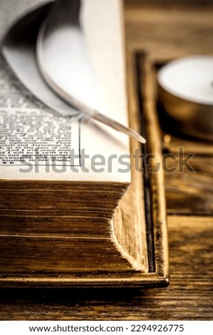Bird feather on old opened Bible