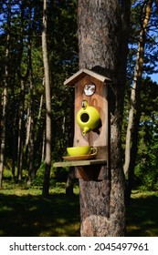 A bird feeder in the form of a teapot and a cup .the feeder is installed on a tree in the park. Wild bird care, home and food. Bird's nest in spring
