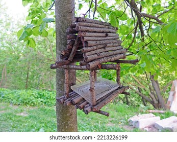 Bird feeder made of wooden sticks and hanging on a tree - Shutterstock ID 2213226199