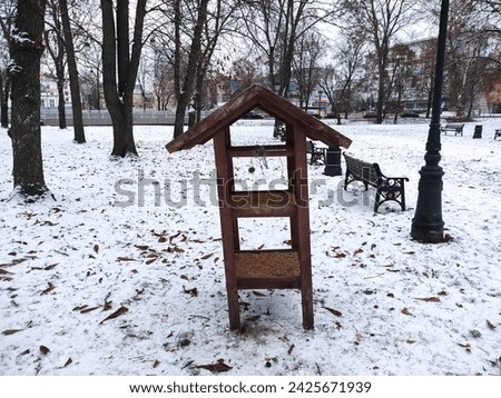 Bird feeder in the winter park in evening