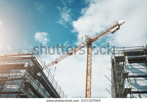 Is it a bird Is it a\
plane No, its a crane. Shot of a crane and building at a\
construction site.