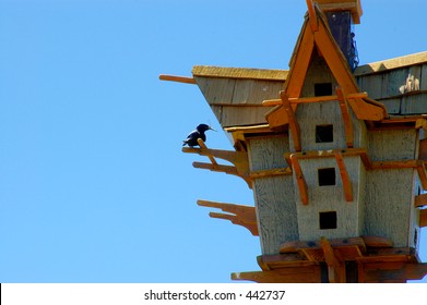 A Bird Returning To An Elaborate Birdhouse With A Dragonfly To Feed Its Young.