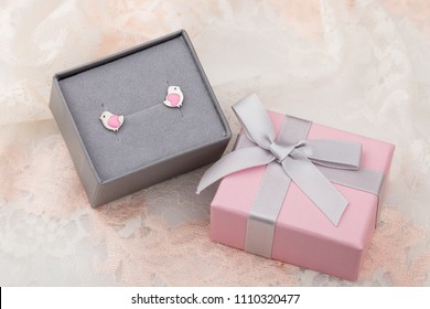 Bird Shape With Hearts Earring Studs In Pink Gift Box On Lace Background. Cute Jewelry For Child Girl