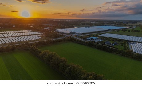 A bird's eye view. Aerial view of green fields with solar panels and netherlands at sunset. View from a flying drone. Top view - Powered by Shutterstock