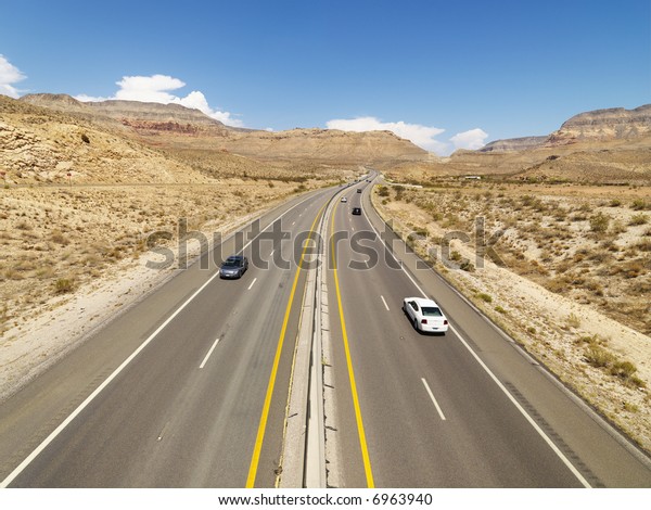 Birds\
eye view of automobiles on rural desert\
highway.
