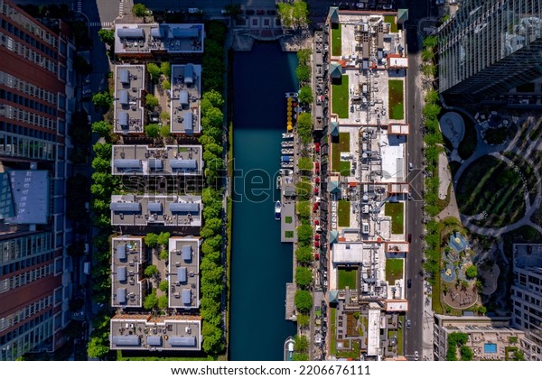 The bird\'s eye view of the building roofs and\
river surrounded by green vegetation\
