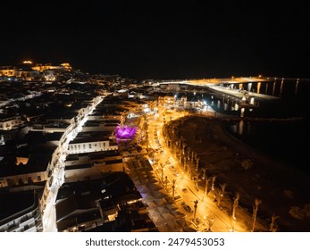 A bird's eye view of a city and coastline at night with numerous lights - Powered by Shutterstock