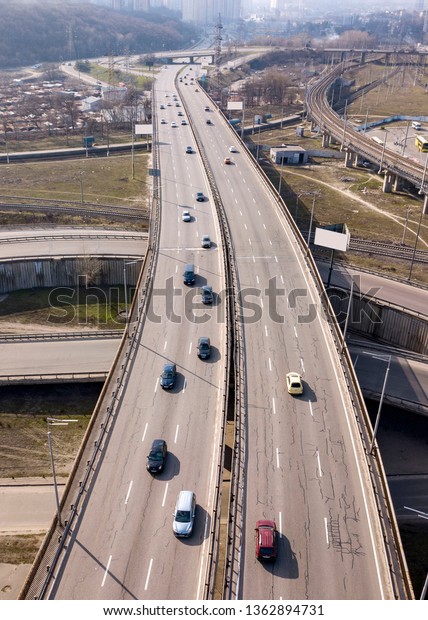 Bird\'s eye view from drone of speedway asphalt\
road, moving fast cars and tracks in a spring sunny day in city\
Kiev, Ukraine.
