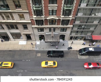 Bird's Eye View Of Midtown Manhattan From A Tall Skyscraper. Looking Down On New York Yellow Taxis And Busy Street Of New York City. Looking Down On New York Street From Above From Tall Building.