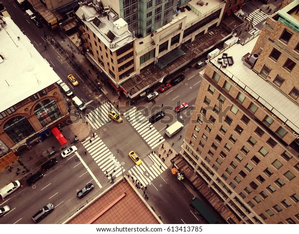 ニューヨーク市の鳥の目から見た景色 超高層ビルからマンハッタンを見下ろしています 車 タクシー 人々が人通りの多い交差点を移動する 白いゼブラが交差し ニューヨークの黄色いキャブが交差している フィルター効果 の写真素材 今すぐ編集