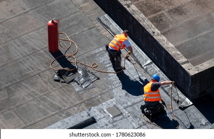 Birds eye view of a roof construction site. Professional bitumen waterproofing on a flat building. - Shutterstock ID 1780623086
