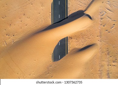 Birds Eye View Of A Sand Covered Empty Road In The Dubai Desert.  