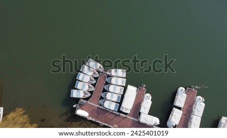 Bird's eye view small ship and boat standing near a bank of a lake, drone shot