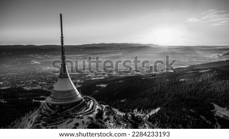 A bird's eye view of snow-covered Jested at sunrise. Photographed on the Jested ridge by drone. Beautiful winter landscape in Liberec region. Black and white