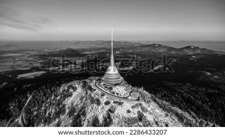 A bird's eye view of snow-covered Jested at sunrise. Photographed on the Jested ridge by drone. Beautiful winter landscape in Liberec region. Black and white