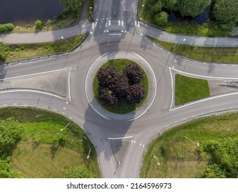 Bird's eye view of a traffic roundabout, roads, lanes with no cars and a path in Partille.  Aerial, drone photography taken from above in Sweden in summer. 