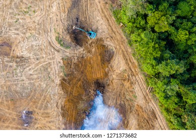 Birds Eye View Of Tropical Rainforest Deforestation.  An Earth Mover Removes Trees Which Are Then Burnt