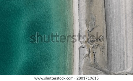 A bird's-eye view from a drone of the river-like microstructures formed by water seeping through the sand on the shore of Lake Salda.