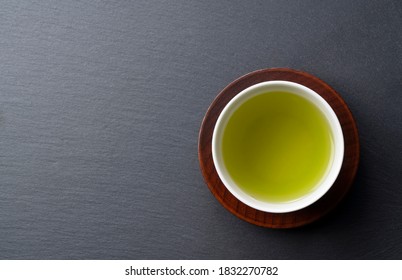 A bird's-eye view of green tea placed on a black background with space. Image of Japanese green tea.
