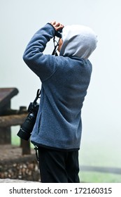 Birdwatcher with  binoculars and camera