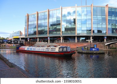 BIRMINGHAM, ENGLAND - OCTOBER 19, 2019: View of a boat on Birmingham Canal in front of Arena Birmingham, England