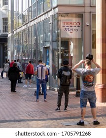 BIRMINGHAM, UK - 2020: A Long Queue Of People Social Distancing At Tesco Supermarket In Birmingham City Centre During Coronavirus Pandemic