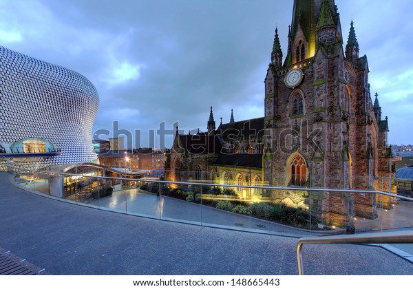 BIRMINGHAM, UK - JANUARY 30:\
Night scene in downtown Birmingham, UK on January 30, 2012 with the\
parish church St. George in the Bullring and the Selfridges\
Department Store.