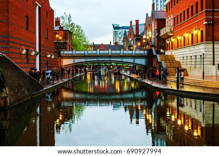 Birmingham, UK. People walking during the rain in the evening at famous Birmingham canal in UK