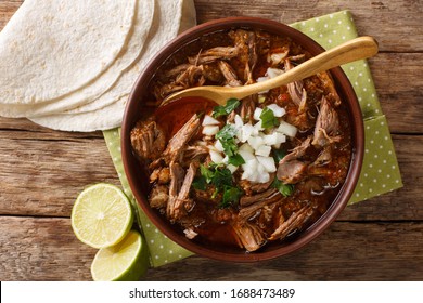 Birria ist ein mexikanisches Gericht ist ein würziges Eintopf, das traditionell aus Ziegenfleisch hergestellt wird, das in einer Schüssel auf dem Tisch zusammenliegt. Horizontale Draufsicht von oben
