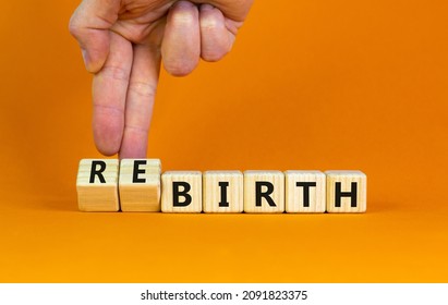 Birth or rebirth symbol. Businessman turns wooden cubes and changes the word birth to rebirth. Beautiful orange table orange background, copy space. Business, birth or rebirth concept.