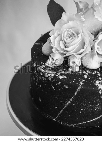birthday black airbrush painted frosted icing cake, two real roses silver sprayed and edible chocolate skull toppers and silver brush strokes