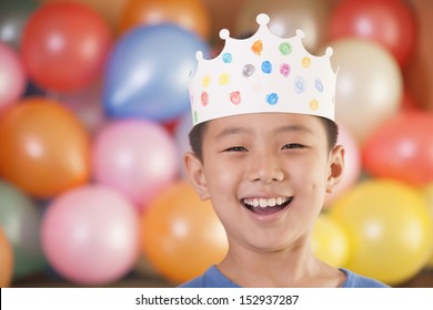 Birthday Boy Wearing A Crown In Front Of Balloons