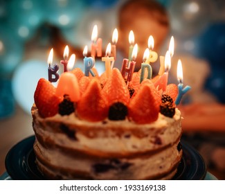 birthday cake with candles against blue balloons - Shutterstock ID 1933169138