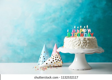 Birthday Cake With Candles On Table Against Color Background