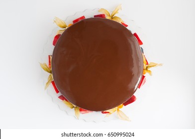 Birthday Cake In Chocolate With Strawberries, Blueberries And Physalis On White Background. Top View. Picture For A Menu Or A Confectionery Catalog.