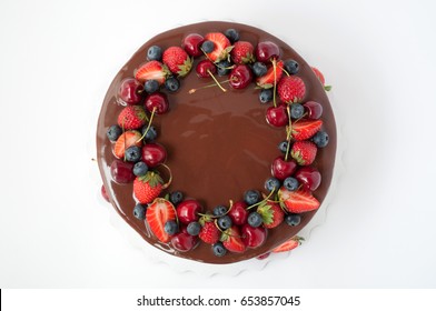 Birthday Cake In Chocolate With Strawberries, Blueberries And Cherry On White Background. Top View. Picture For A Menu Or A Confectionery Catalog.