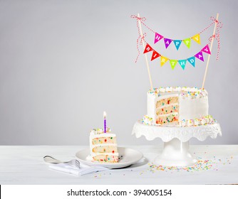 Birthday cake with colorful bunting and sprinkles
