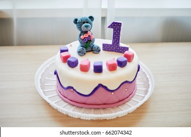 Birthday cake decorated with bear and number one.