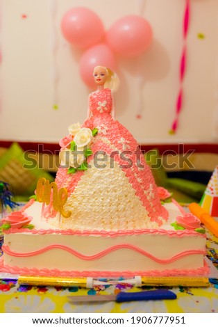 Birthday cake display in pink color girls birthday cake with dolly insert.
