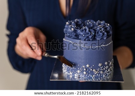 Birthday cake held by a baker in a bakery. Portrait of caucasian woman sharing fresh cake. Chef holding plate with sweet dessert. Unrecognizable female cook showing refreshing dessert. Stockfoto © 