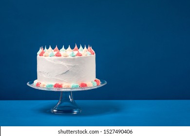 Birthday Cake With Pastel Icing, C Over A Blue Background.