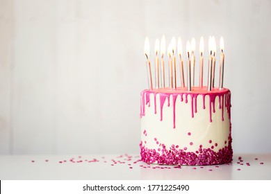 Birthday Cake With Pink Drip Icing And Birthday Candles With Copy Space To Side