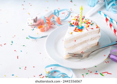 Birthday cake slice on birthday party decorated table.  Slice of Birthday Cake with white whipped cream, sugar sprinkles funfetti and candle, copy space